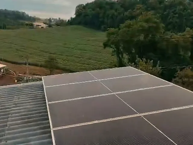 Painéis solares num telhado, com a lavoura ao fundo, durante uma obra da Freu Energia